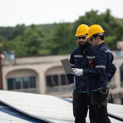 Engineer team checking solar cell on the roof of the factory